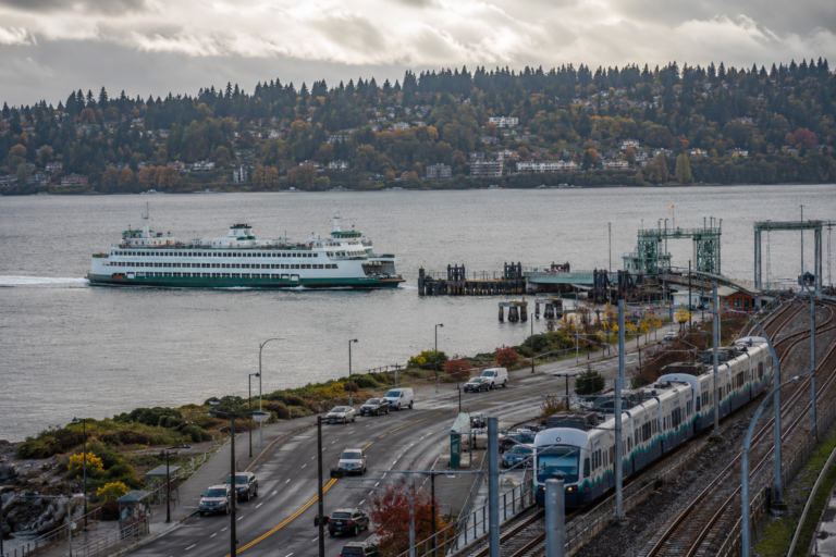 Balsa, trem leve e rodovia no Puget Sound, ilustrando a integração entre diferentes meios de transporte na região de Washington.