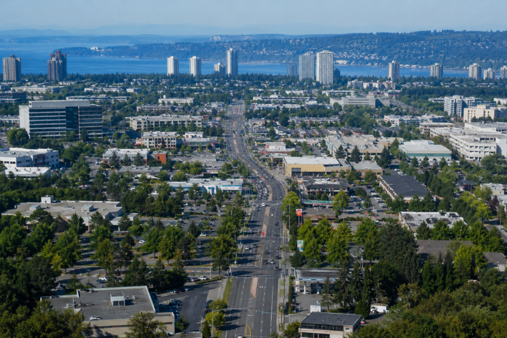 Vista ampla de uma região urbana contínua no Puget Sound, com bairros, áreas comerciais e edifícios conectando cidades vizinhas que parecem formar uma única área metropolitana.