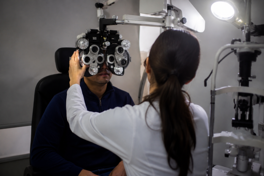 Profissional de saúde realiza exame de visão em paciente utilizando equipamento oftalmológico em uma clínica.