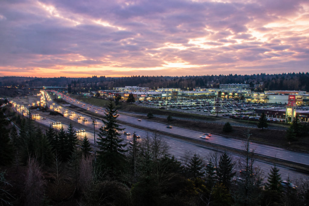 Vista elevada de Lynnwood ao entardecer mostrando a Interstate 5, áreas comerciais e bairros arborizados, destacando o papel da cidade como importante centro de transporte e serviços no sul de Snohomish County.