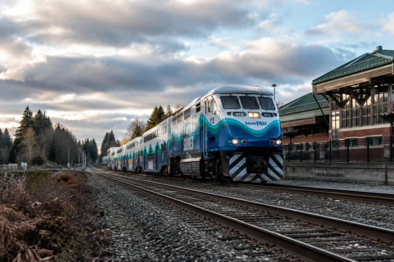 Trem Sounder circulando pelos trilhos ao lado de uma estação na região de Puget Sound, Washington.
