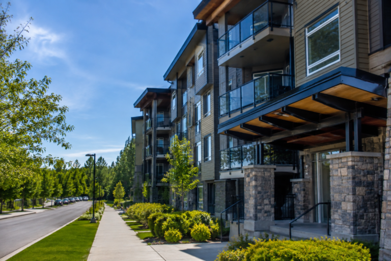 Condomínio residencial moderno nos Estados Unidos com apartamentos de propriedade individual (condos), áreas comuns ajardinadas e arquitetura contemporânea em um dia ensolarado.