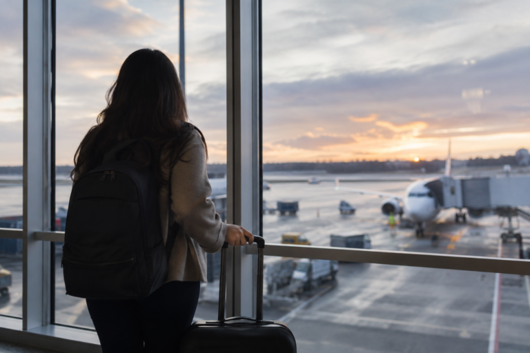 Uma mulher olhando na janela de um aeroporto